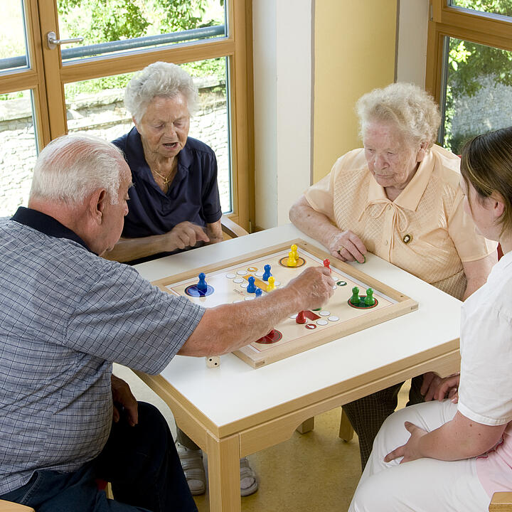 Senior*innen spielen ein Brettspiel.